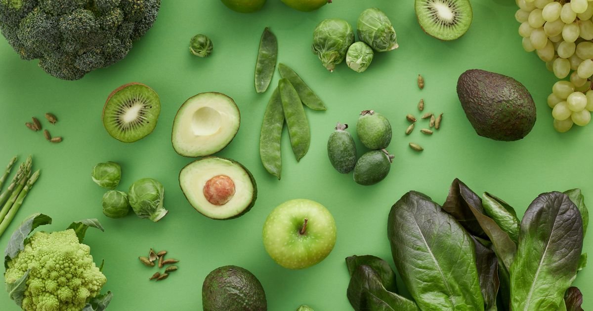Variedade de frutas e legumes frescos sobre fundo verde