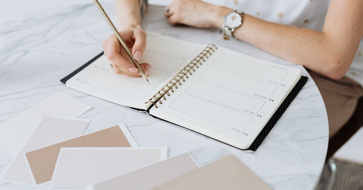 Pessoa escrevendo em um planner para organizar a rotina